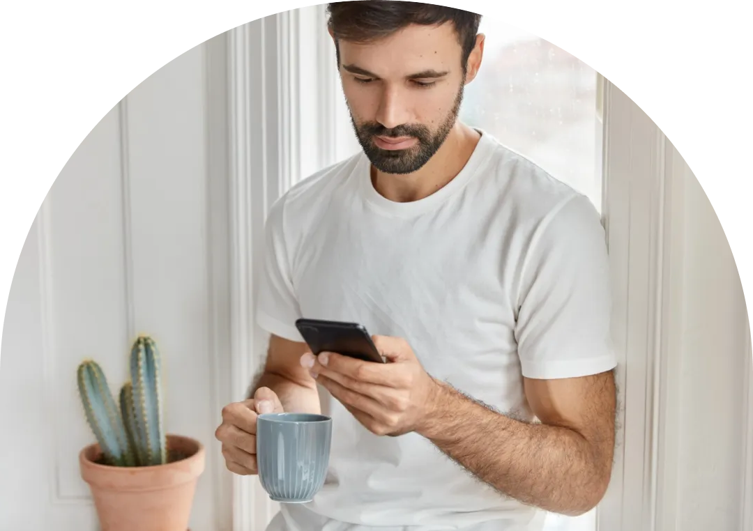 A hand holding a magnifying glass over white tiles spelling out the word 'FRAUD' on a white background. The magnifying glass enlarges the letter 'F' in the word.