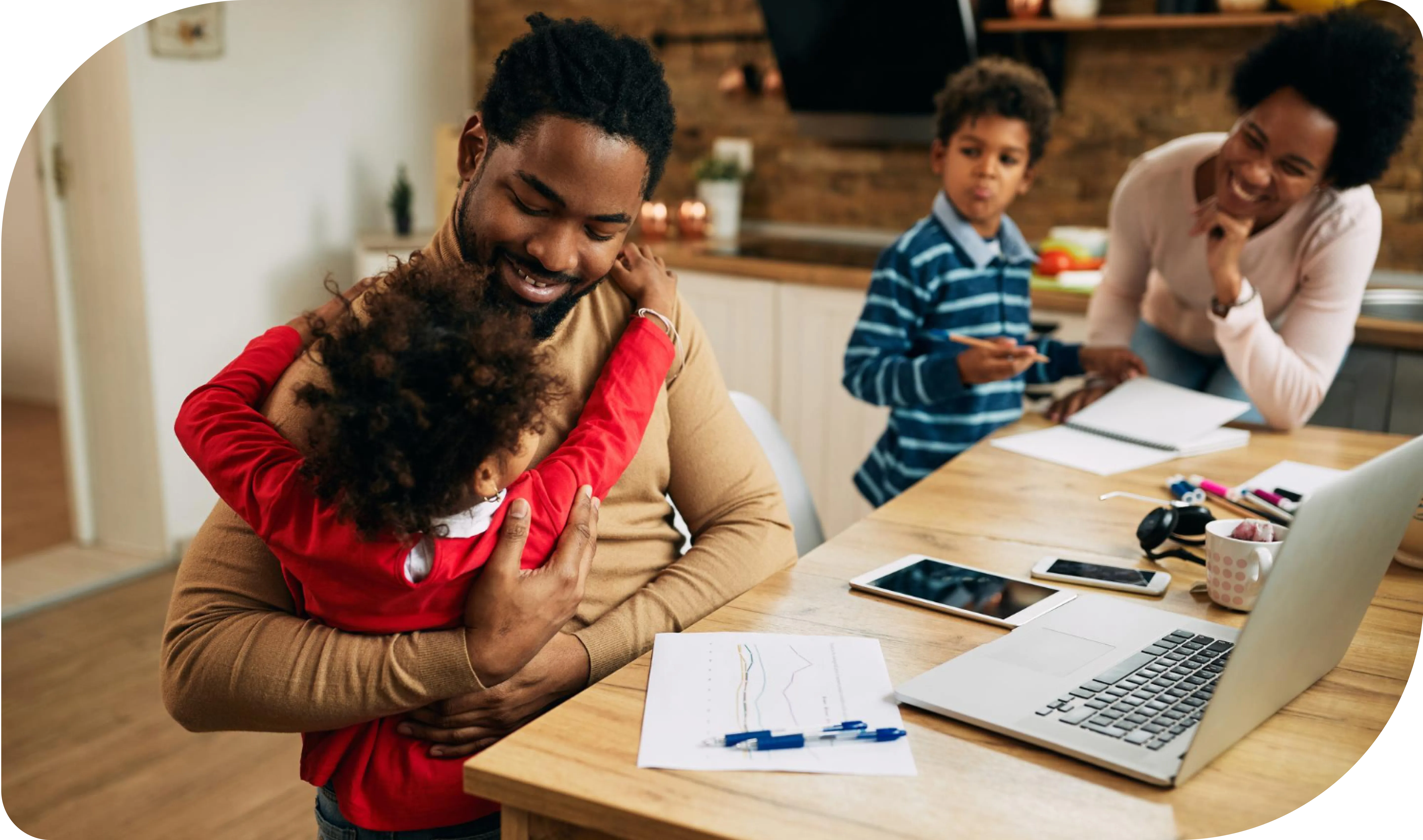 A family at a kitchen table, managing unexpected bills. A man hugs a child amidst papers, smartphones, a laptop, a tablet, and a toy. Nearby, a smiling woman with pen and paper, and an older child stands nearby.